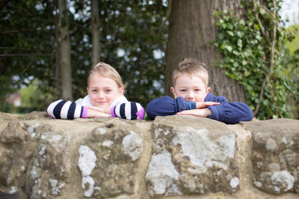 portrait of two children leaning over a wall in Knole Park Sevenoaks